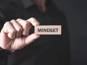 Peter, a counsellor in Chislehurst, holding a wooden block with the word 'Mindset' engraved on it, symbolizing his focus on mental well-being.